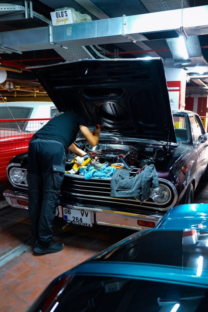 Mécanicien penché sur le moteur d’une voiture ancienne