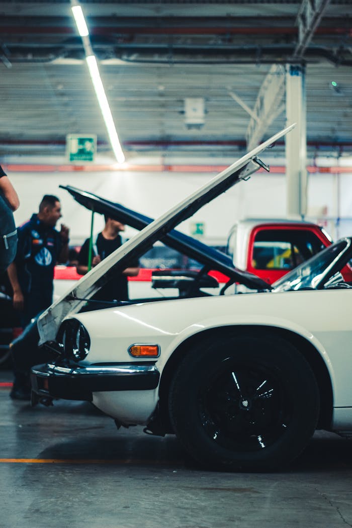 Atelier avec une voiture blanche capot ouvert